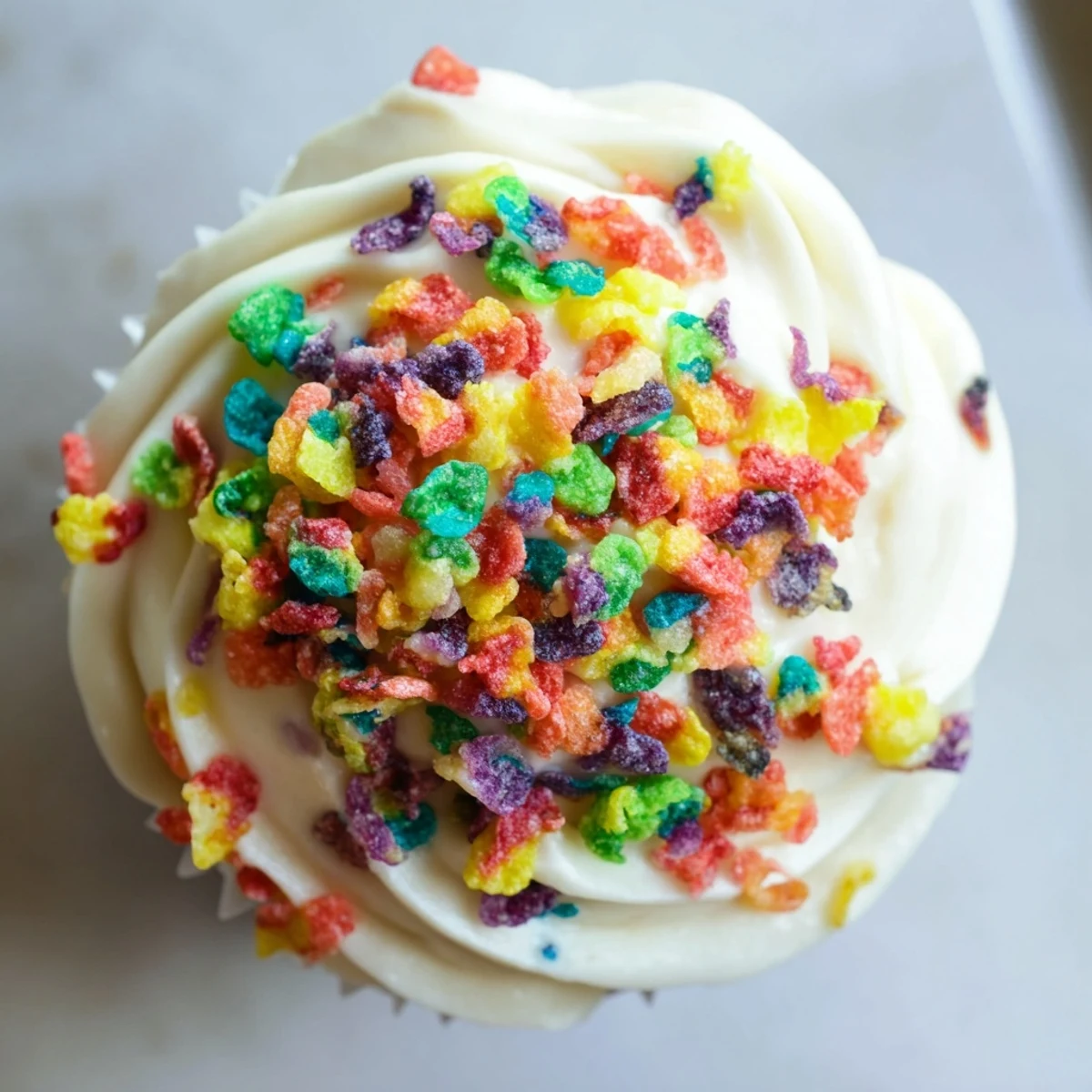 Smooth creamy Fruity Pebbles frosting generously spread on a cake with extra crunchy cereal garnish