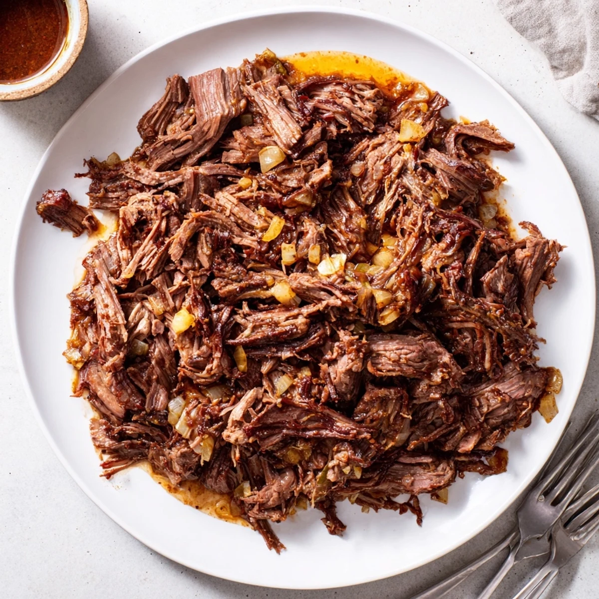 Juicy shredded Mexican-style beef barbacoa served in warm corn tortillas with lime wedges