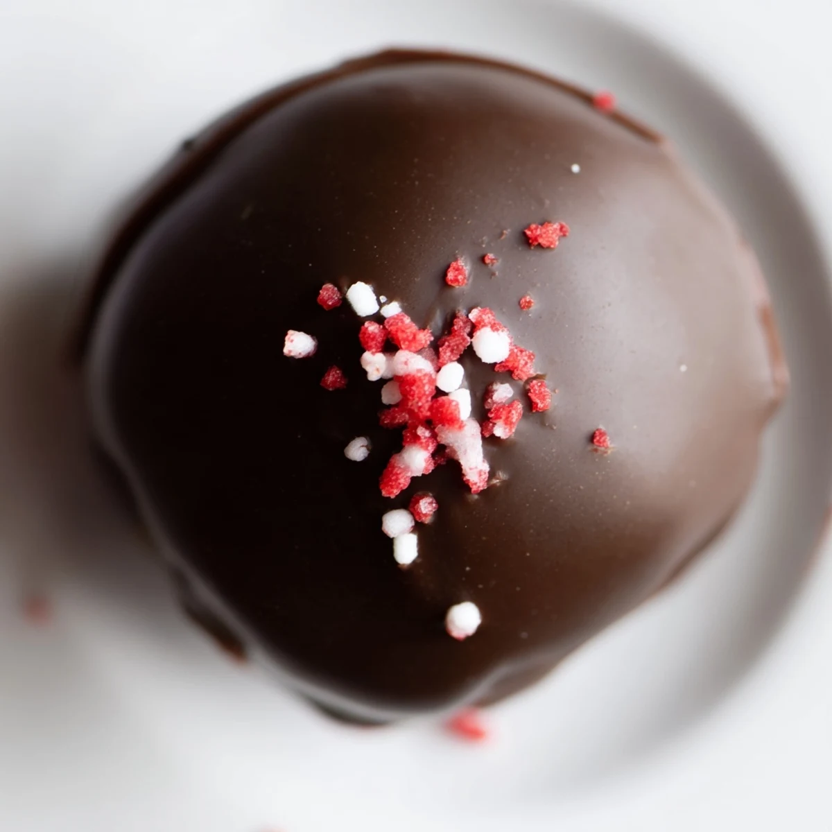 Creamy red velvet cheesecake balls on a white plate ready for holiday parties and gatherings