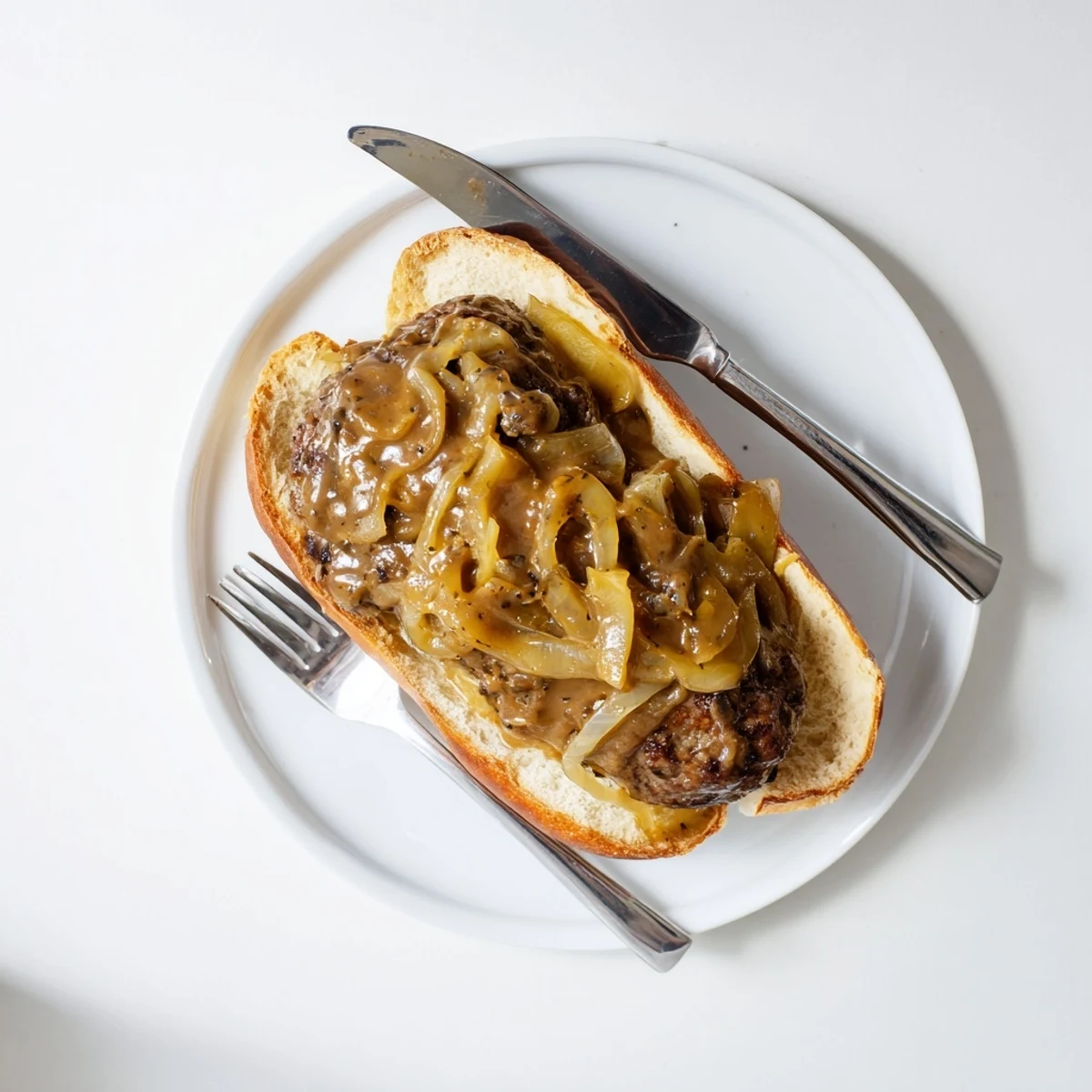 Golden buns cradling tender smothered hamburger steak sandwiches under rich caramelized onion gravy