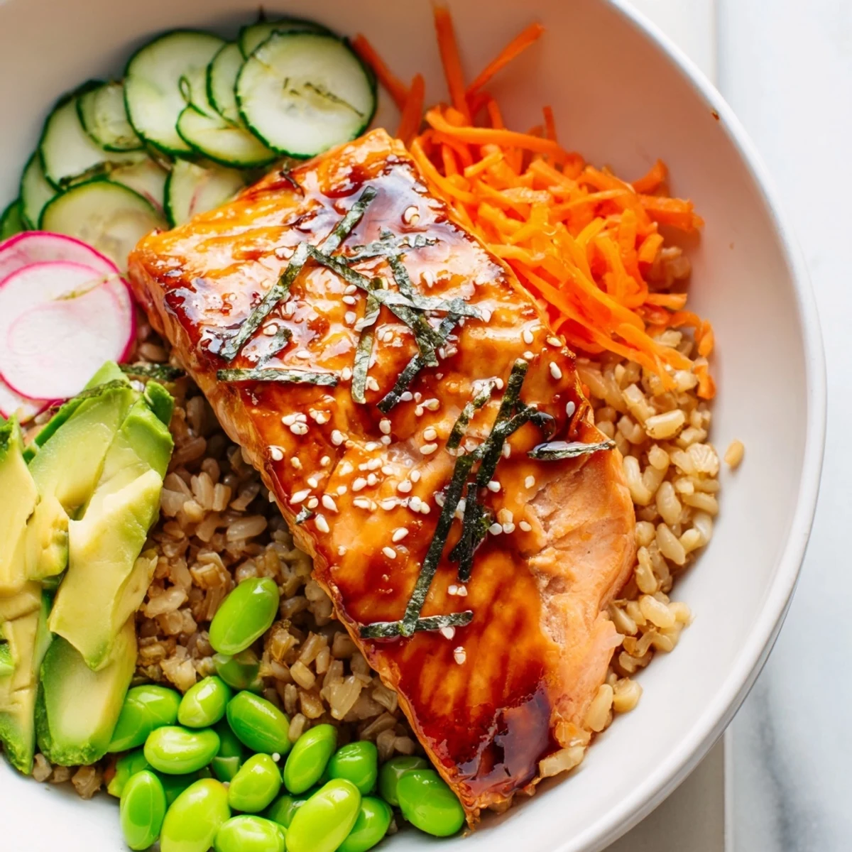 Miso salmon grain bowl drizzled with dressing and sprinkled with sesame seeds