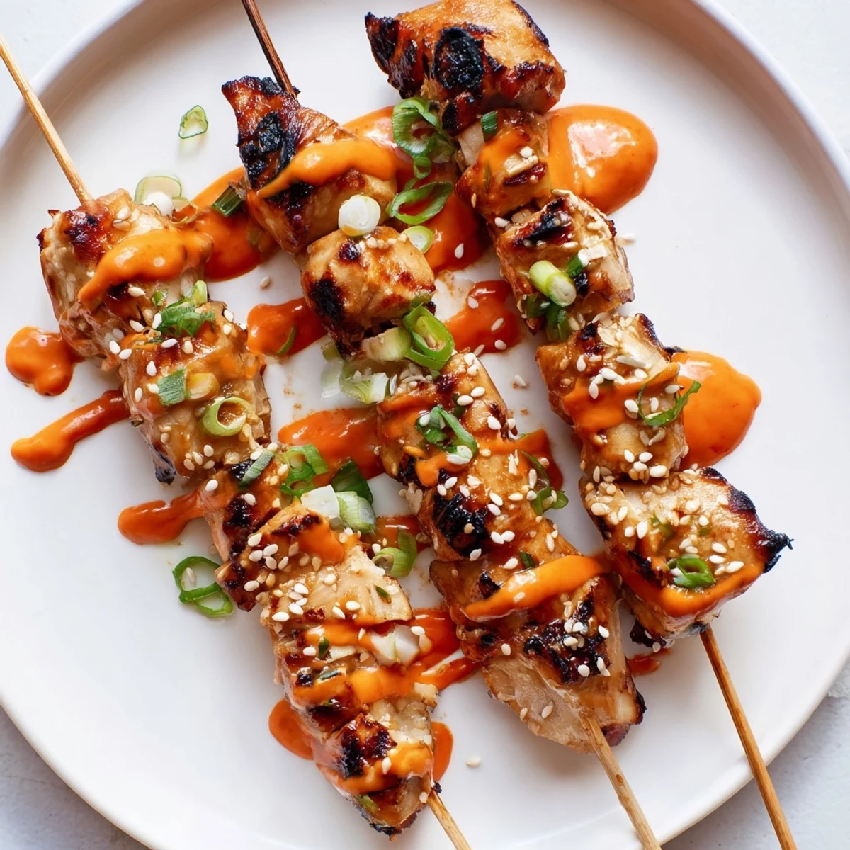 Juicy Bang Bang Chicken Skewers grilled golden and drizzled with creamy spicy sauce