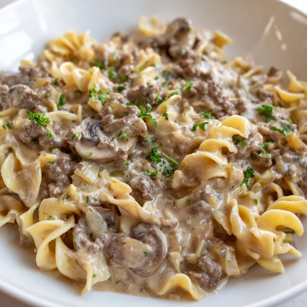 Hearty Hamburger Stroganoff served over tender egg noodles with creamy sauce
