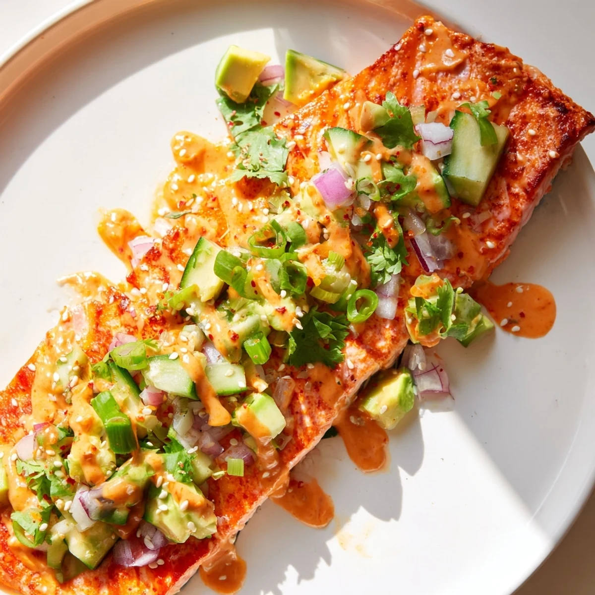Crispy baked Bang Bang Salmon drizzled with spicy cream sauce and fresh salsa