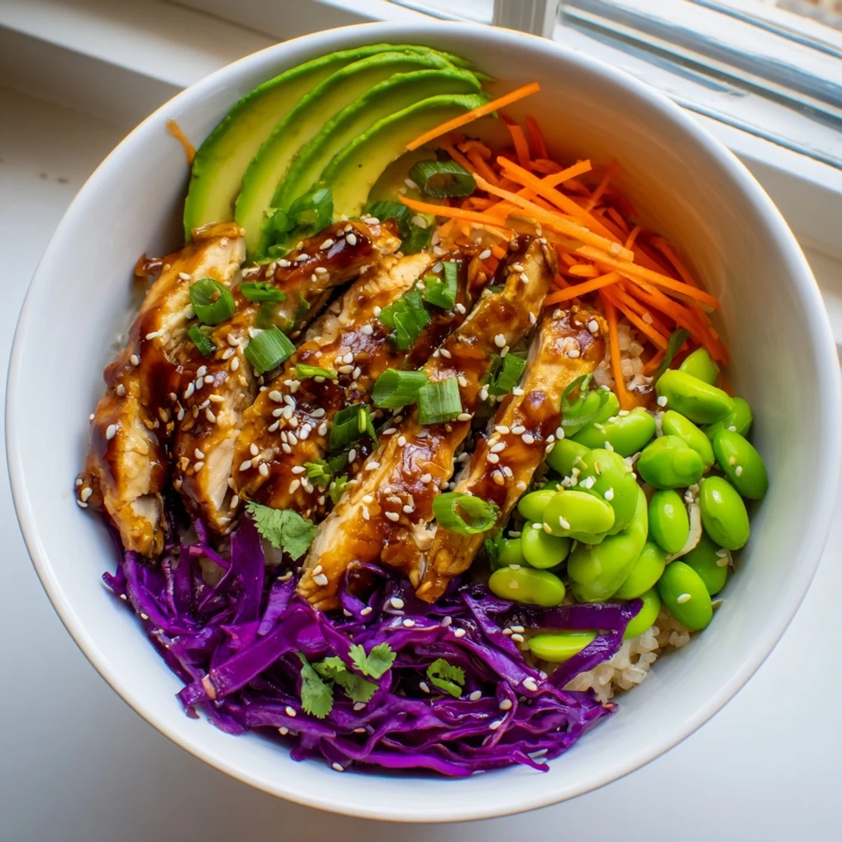 Asian Inspired Chicken Power Bowl topped with edamame scallions and a tangy ginger drizzle