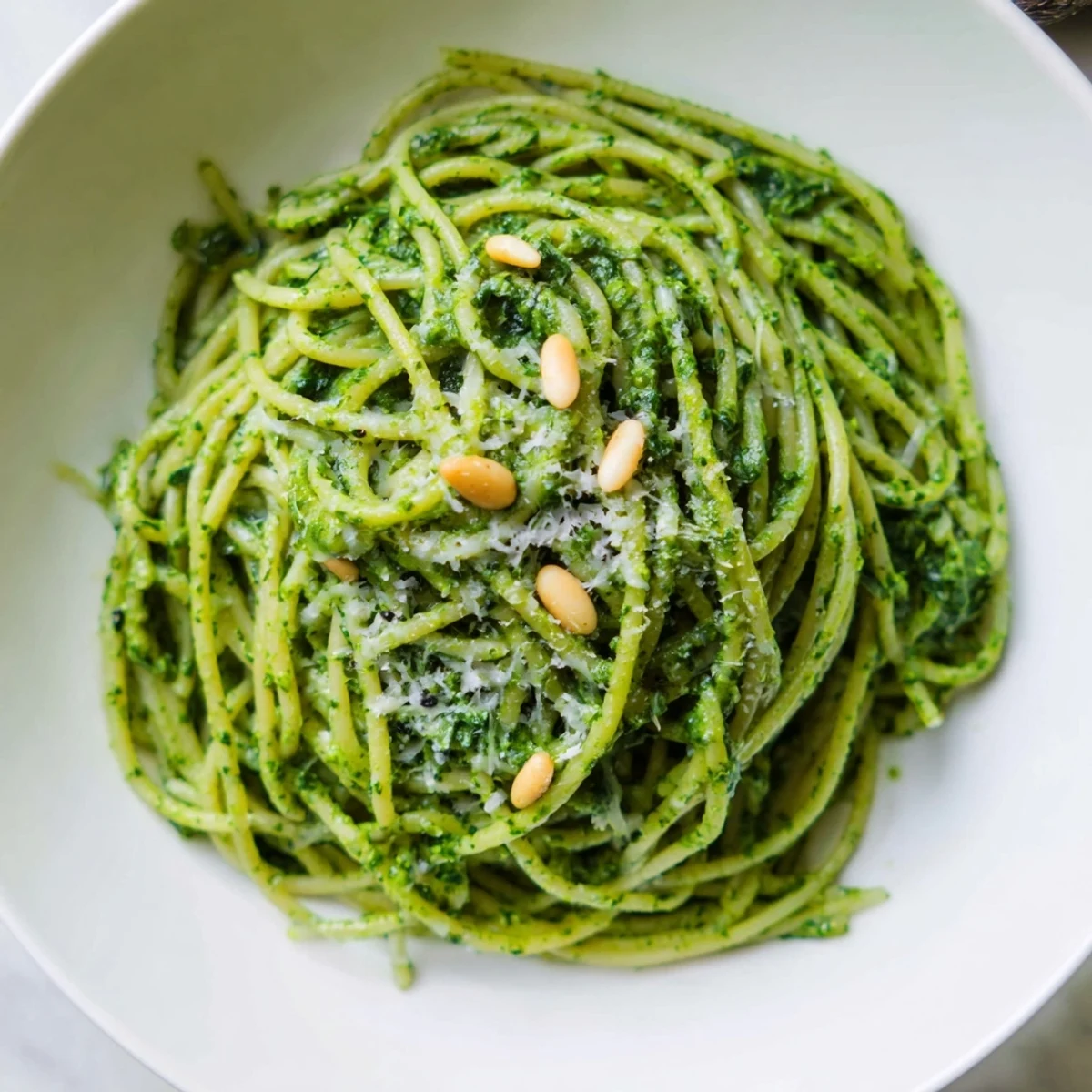 A steaming bowl of wild garlic pesto pasta coated in bright green herb sauce