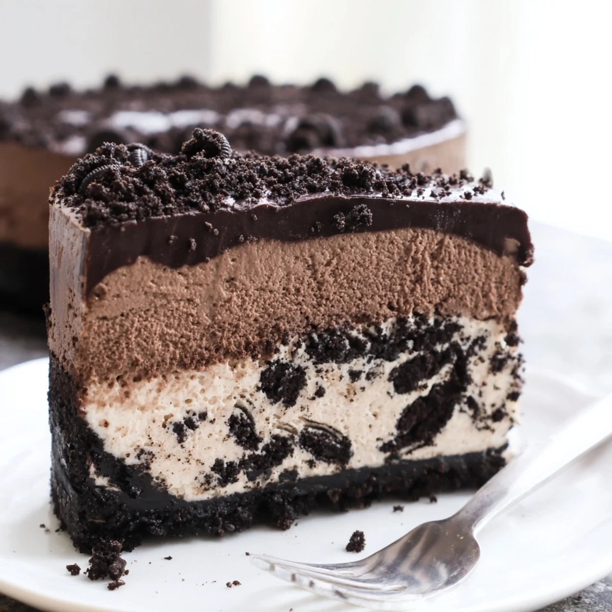 Decadent Oreo chocolate cheesecake finished with crushed cookies and a smooth chocolate topping