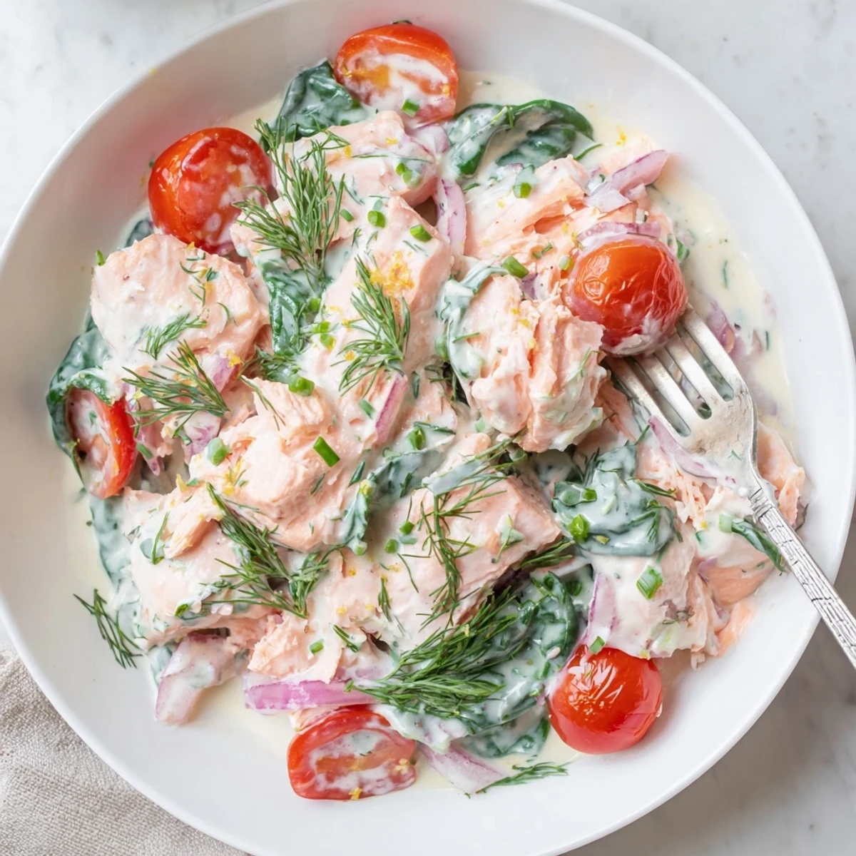 Healthy creamy leftover salmon recipe topped with fresh chives in a white bowl
