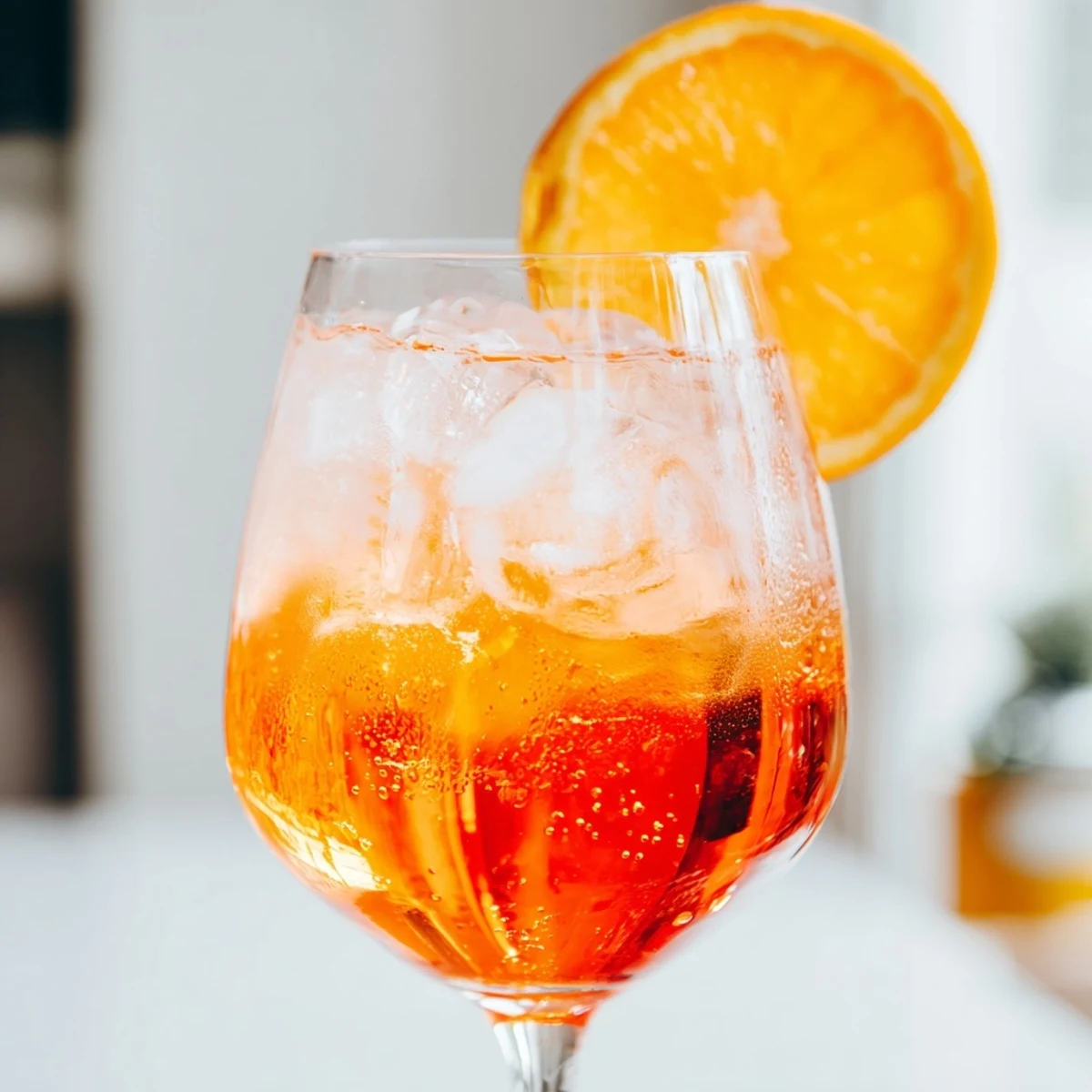 Vibrant Spritz cocktail with orange slice garnish served over ice in a glass.  