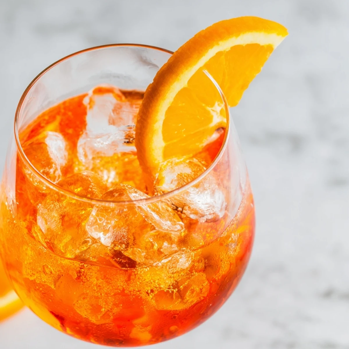 Refreshing Spritz cocktail featuring Prosecco, Aperol, soda water, and a fresh orange wheel.  