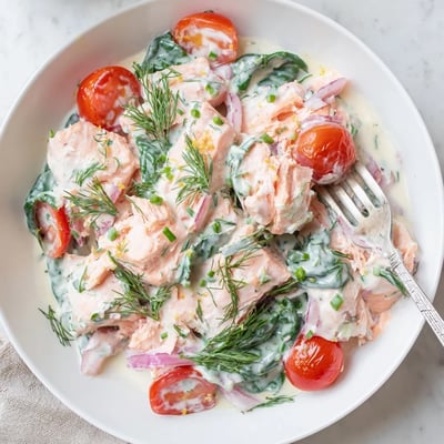 Healthy creamy leftover salmon recipe topped with fresh chives in a white bowl