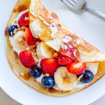 Fluffy pancake tacos folded taco-style and stuffed with scrambled eggs and crumbled bacon