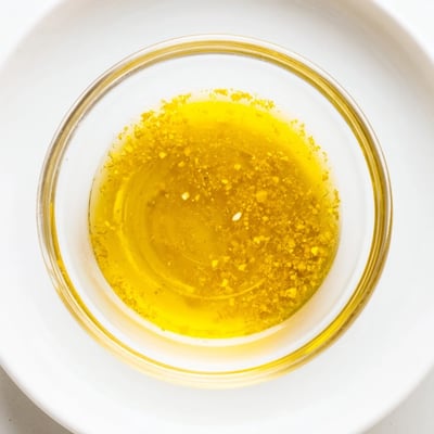 Close-up of lemon vinaigrette dressing recipe with olive oil and lemon zest.  