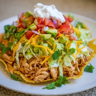 Crispy corn tortillas loaded with spiced chicken, cheese, and vibrant Mexican toppings.  